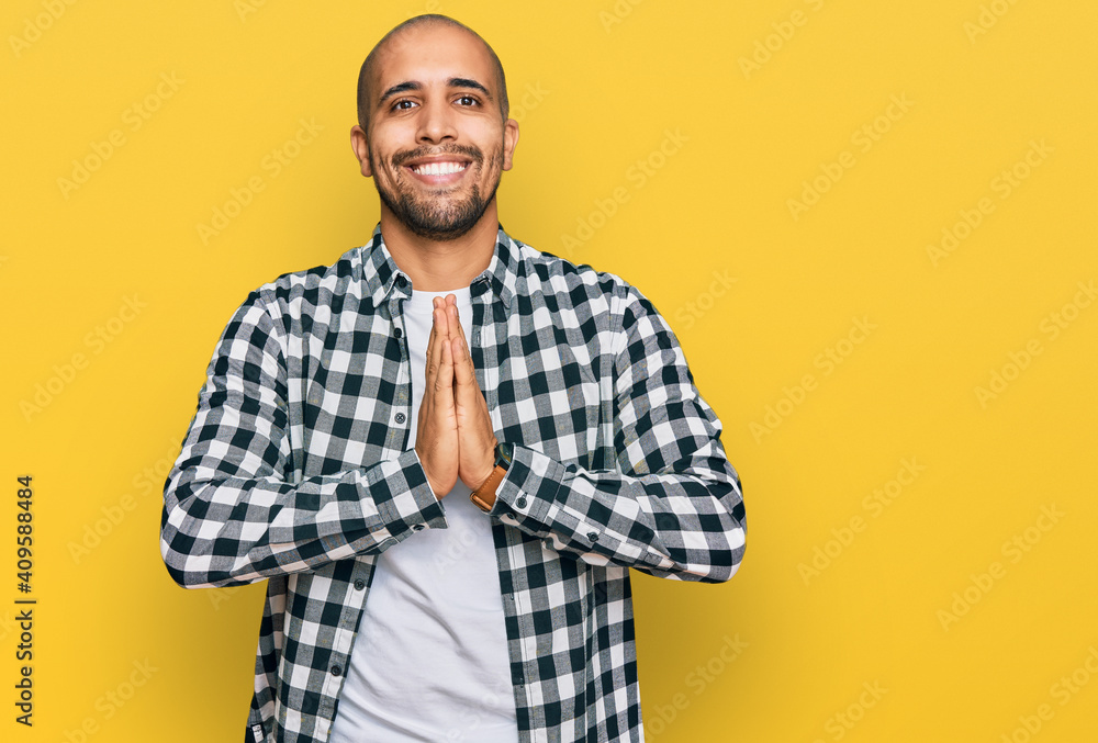 Hispanic adult man wearing casual clothes praying with hands together asking for forgiveness smiling confident. Hispanic adult man wearing casual clothes praying with hands together asking for forgiveness smiling confident.
