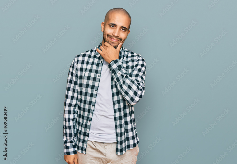 Hispanic adult man wearing casual clothes looking confident at the camera smiling with crossed arms and hand raised on chin. thinking positive. Hispanic adult man wearing casual clothes looking confident at the camera smiling with crossed arms and hand raised on chin. thinking positive.
