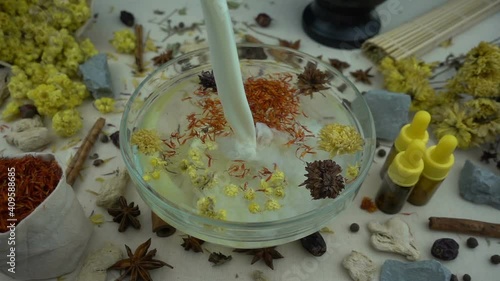 Woman's hand puts ingredients to the glassware for preparation domestic cosmetics in slow motion. Alternative medicine, organic cosmetics, aromatherapy and natural care concept.