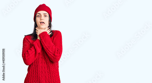 Young beautiful girl wearing sweater and wool cap shouting and suffocate because painful strangle. health problem. asphyxiate and suicide concept.