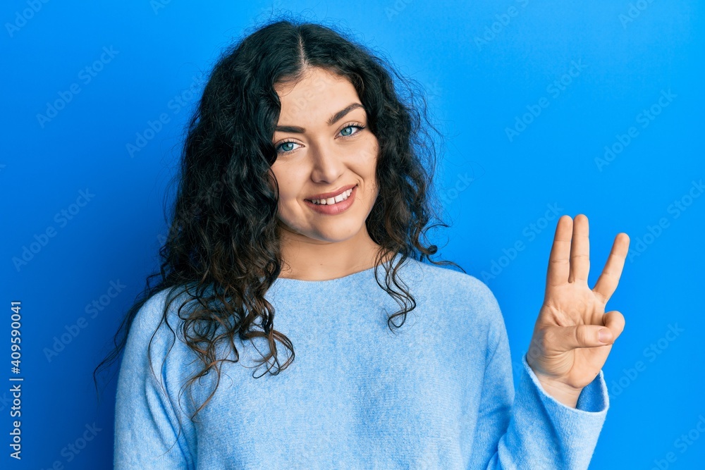 Young brunette woman with curly hair wearing casual clothes showing and pointing up with fingers number three while smiling confident and happy. Young brunette woman with curly hair wearing casual clothes showing and pointing up with fingers number three while smiling confident and happy.