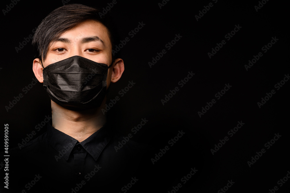Asian man with medical face mask to protection the coronavirus. Young Asian man living in city with polluted air Asian man with medical face mask to protection the coronavirus. Young Asian man living in city with polluted air