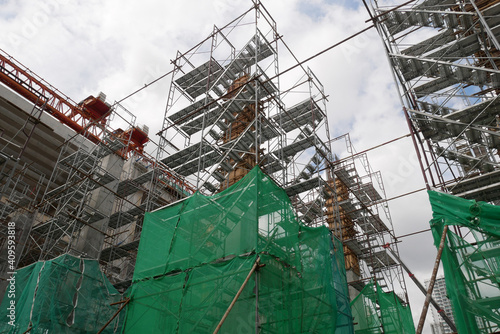 SHAH ALAM, MALAYSIA -AUGUST 8, 2020: Temporary staircase and falsework are used as the temporary support during construction. It is wrapped with safety netting for safety purposes. Installed by worker photo