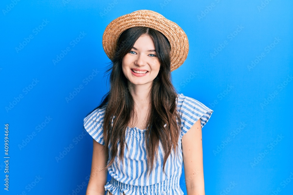 Young beautiful caucasian girl wearing summer hat with a happy and cool smile on face. lucky person.