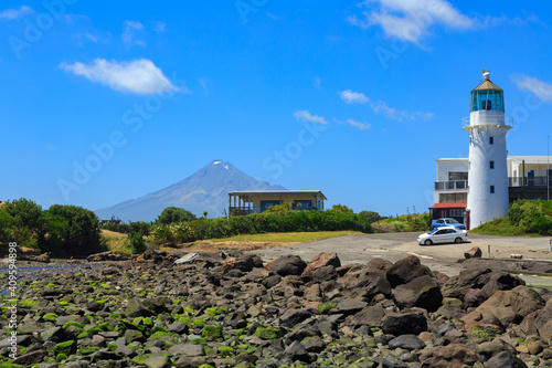 The Historic Cape Egmont Lighthouse in the Taranaki Region, New Zealand, with Mount Taranaki in the background