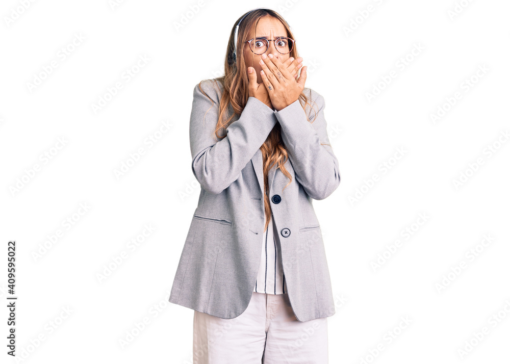 Young beautiful blonde woman wearing call center agent headset shocked covering mouth with hands for mistake. secret concept. Young beautiful blonde woman wearing call center agent headset shocked covering mouth with hands for mistake. secret concept.