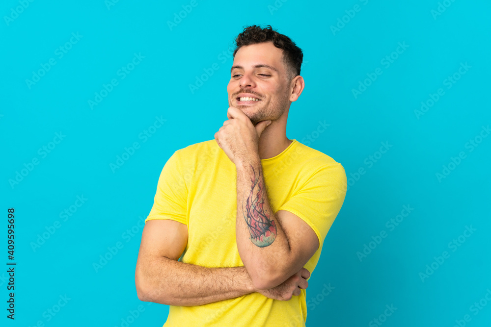 Young caucasian handsome man isolated on blue background looking to the side and smiling Young caucasian handsome man isolated on blue background looking to the side and smiling