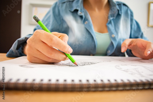Slika na platnu Close-up of woman designer sketching by hand using pencil