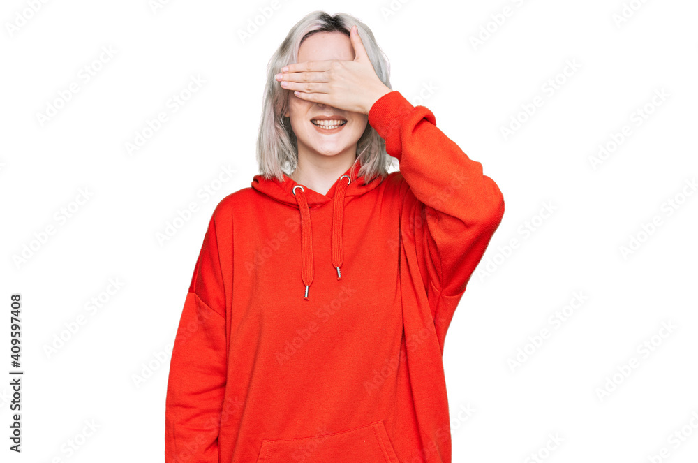 Young blonde girl wearing casual clothes smiling and laughing with hand on face covering eyes for surprise. blind concept. Young blonde girl wearing casual clothes smiling and laughing with hand on face covering eyes for surprise. blind concept.