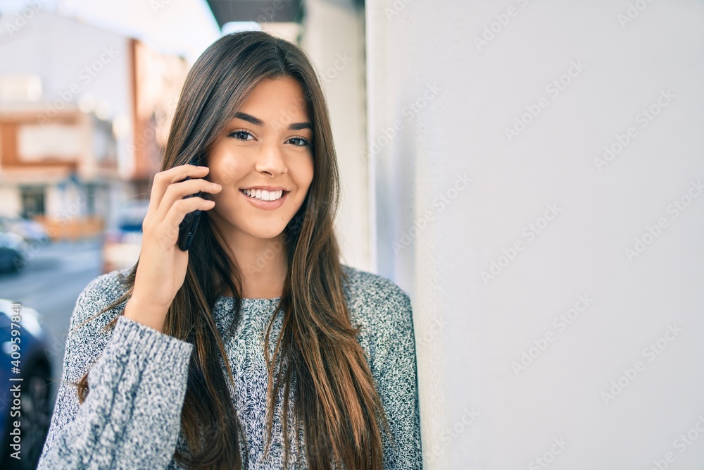 Young beautiful hispanic girl smiling happy talking on the smartphone at the city. Young beautiful hispanic girl smiling happy talking on the smartphone at the city.