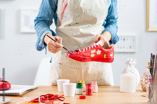 Woman doing arts and crafts hobby, repainting and customizing shoes