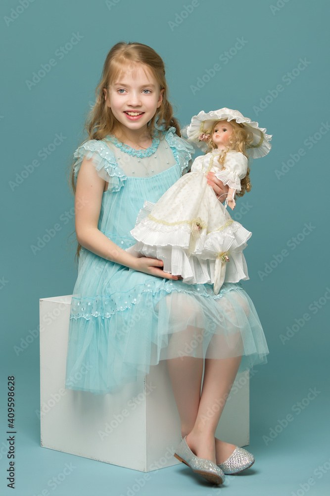 Cute little girl playing with a doll. Cute little girl playing with a doll.