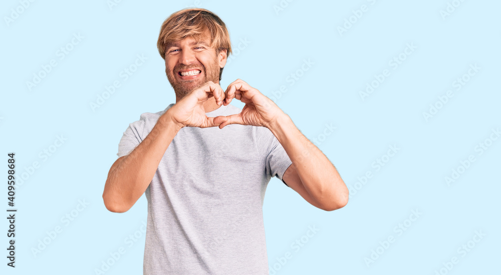 Handsome caucasian man with beard wearing casual tshirt smiling in love showing heart symbol and shape with hands. romantic concept. Handsome caucasian man with beard wearing casual tshirt smiling in love showing heart symbol and shape with hands. romantic concept.