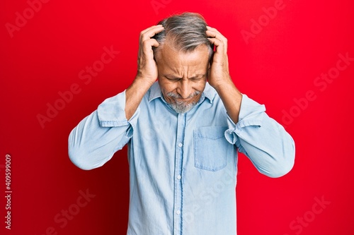 Middle age grey-haired man wearing casual clothes suffering from headache desperate and stressed because pain and migraine. hands on head.