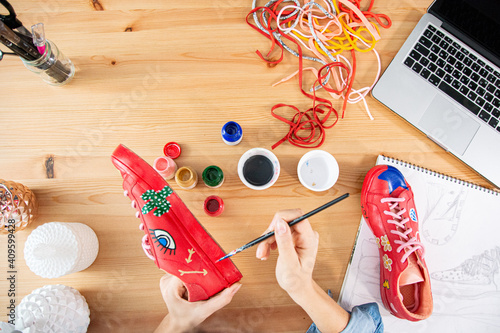 Fashion entrepreneur working and customizing shoes in workshop, eco-fashion project photo