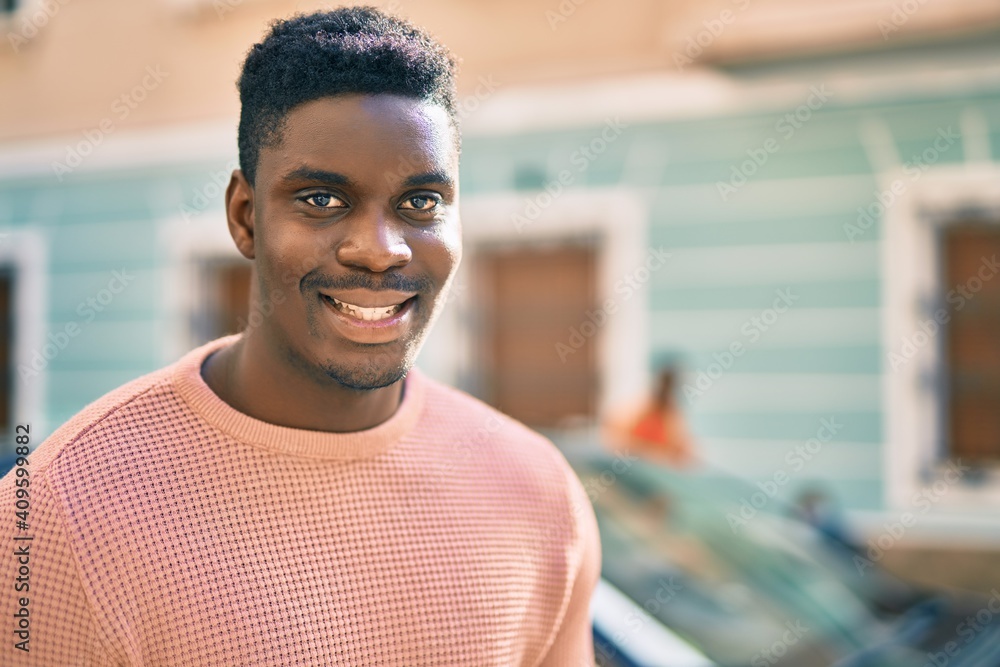 Young african american man smiling happy standing at the city. Young african american man smiling happy standing at the city.
