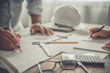 engineer working in office with blueprints, inspection in workplace for architectural plan, construction project ,Business construction.