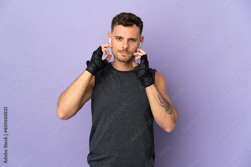 Young caucasian handsome man isolated on purple background listening music Young caucasian handsome man isolated on purple background listening music