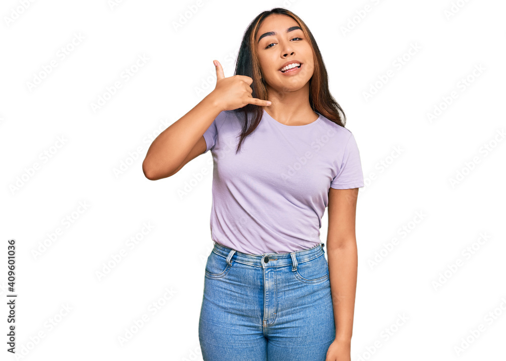 Young latin woman wearing casual clothes smiling doing phone gesture with hand and fingers like talking on the telephone. communicating concepts. Young latin woman wearing casual clothes smiling doing phone gesture with hand and fingers like talking on the telephone. communicating concepts.