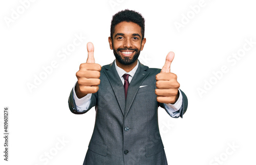 Young african american man wearing business clothes approving doing positive gesture with hand, thumbs up smiling and happy for success. winner gesture.