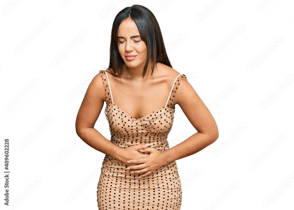 Young beautiful hispanic girl wearing sexy party dress with hand on stomach because indigestion, painful illness feeling unwell. ache concept. Young beautiful hispanic girl wearing sexy party dress with hand on stomach because indigestion, painful illness feeling unwell. ache concept.