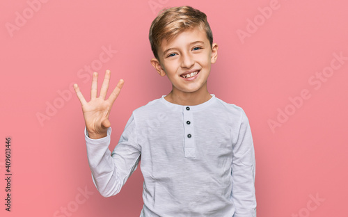Little caucasian boy kid wearing casual clothes showing and pointing up with fingers number four while smiling confident and happy.