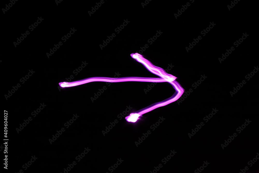 Arrow sign drawn with purple light. Long exposure. Arrow sign drawn with purple light. Long exposure.