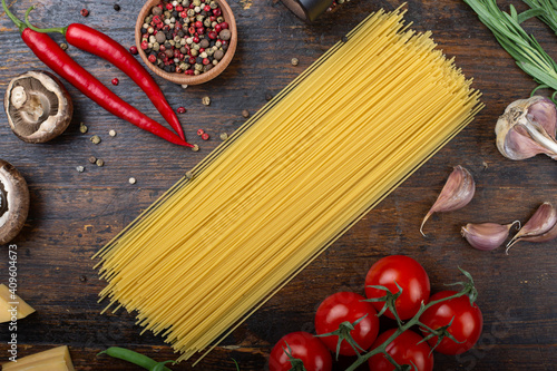 Spaghetti and Ingredients on an old and vintage wooden table. Italian Cuisine.