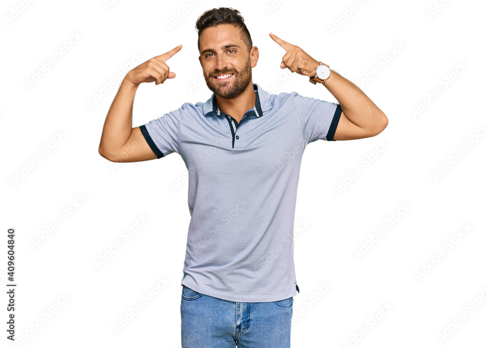 Handsome man with beard wearing casual clothes smiling pointing to head with both hands finger, great idea or thought, good memory Handsome man with beard wearing casual clothes smiling pointing to head with both hands finger, great idea or thought, good memory