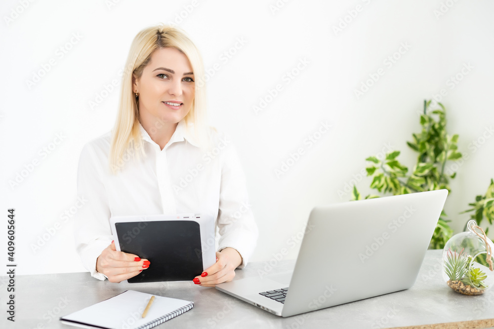 Beautiful young woman working on her laptop in her office. Beautiful young woman working on her laptop in her office.