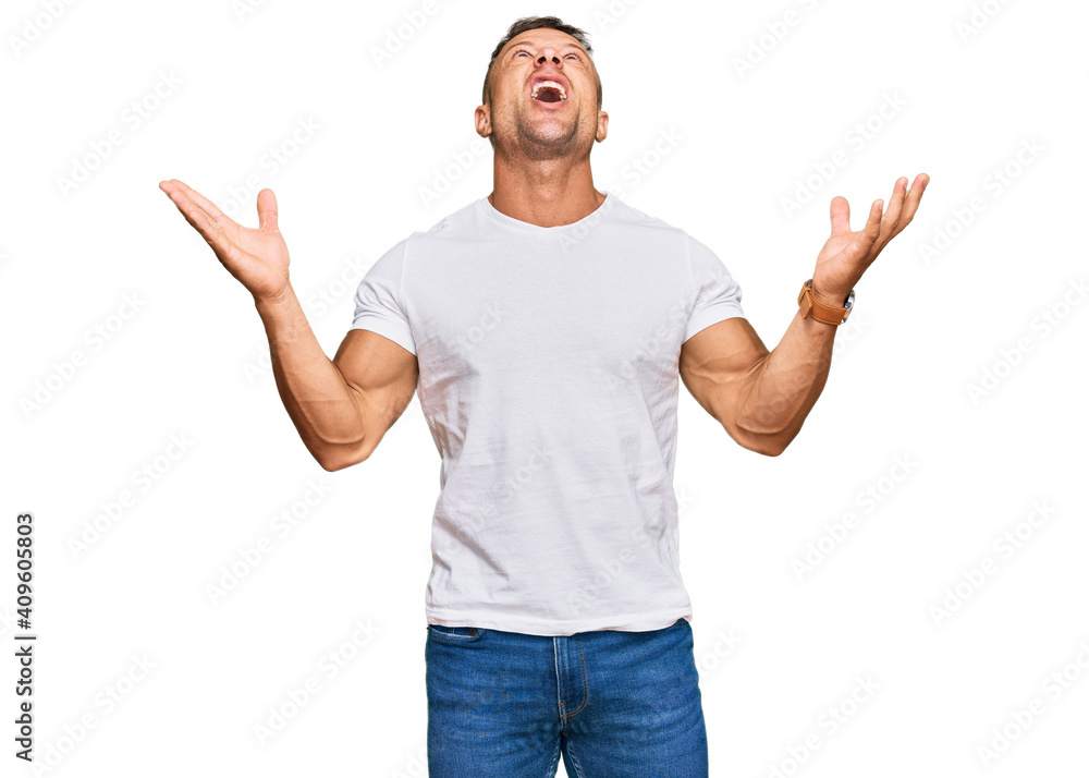Handsome muscle man wearing casual white tshirt crazy and mad shouting and yelling with aggressive expression and arms raised. frustration concept. Handsome muscle man wearing casual white tshirt crazy and mad shouting and yelling with aggressive expression and arms raised. frustration concept.