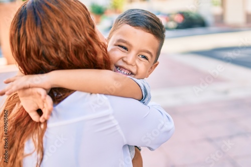 Adorable latin mother and son smiling happy hugging at the city. photo