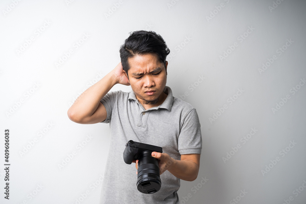 Young Asian man face expression with dslr or mirrorless camera. Photography, creative industry. Isolated selective focus. Young Asian man face expression with dslr or mirrorless camera. Photography, creative industry. Isolated selective focus.