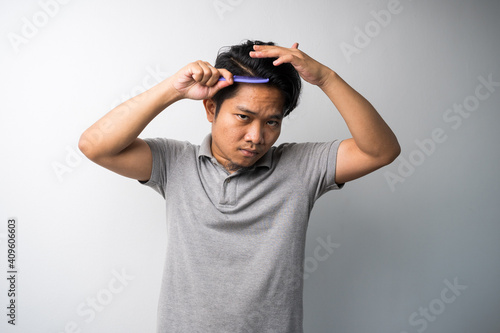 young Asian man comb his hair isolated selective focus