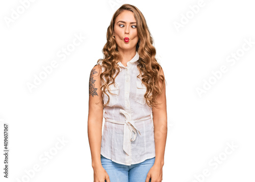 Young blonde girl wearing casual clothes making fish face with lips, crazy and comical gesture. funny expression. © Krakenimages.com