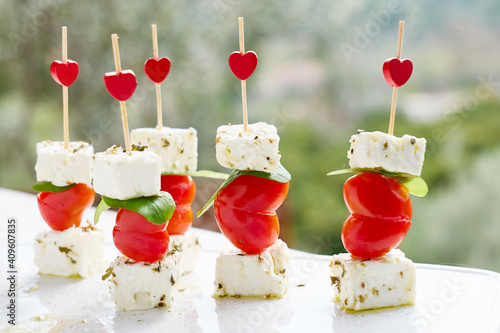 Valentines day or birthday romantic snacks.Canapes with cheese and heart-shaped piccadilly tomatoes.Original food for Valentine's Day, romantic dinner photo