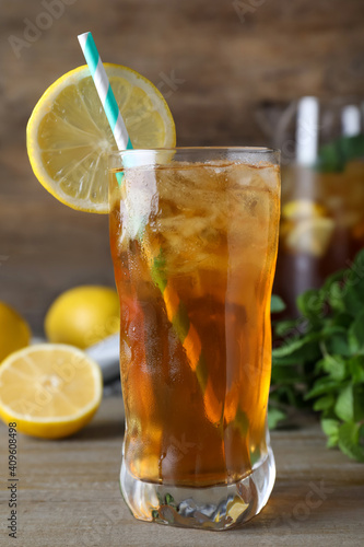 Delicious iced tea in glass on wooden table, closeup