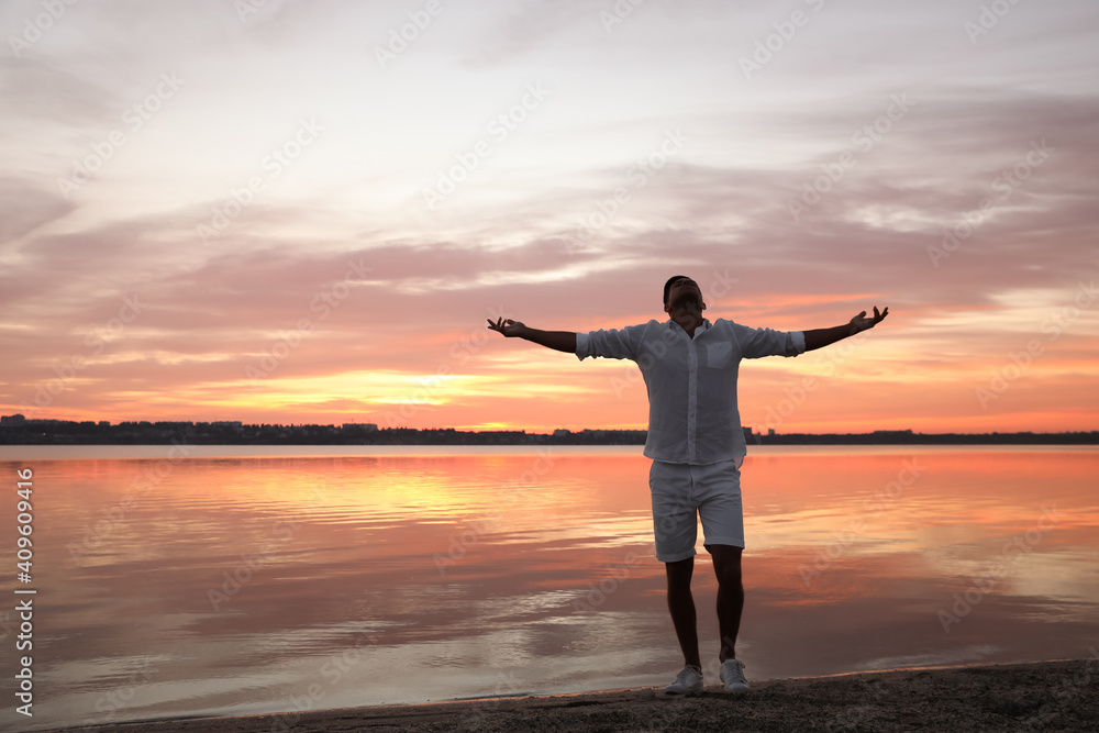 Man near river at sunset, space for text. Nature healing power Man near river at sunset, space for text. Nature healing power
