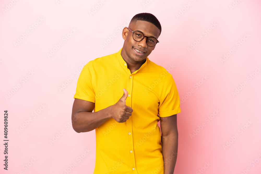 Young latin man isolated on pink background giving a thumbs up gesture Young latin man isolated on pink background giving a thumbs up gesture