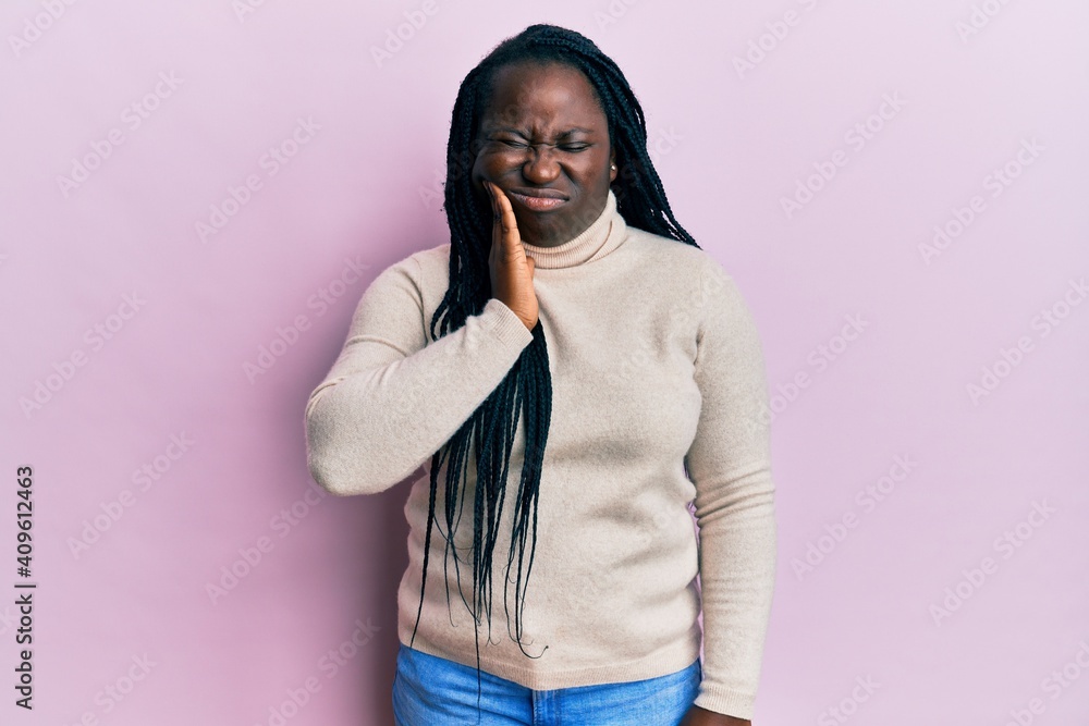 Fototapeta premium Young black woman with braids wearing casual winter sweater touching mouth with hand with painful expression because of toothache or dental illness on teeth. dentist