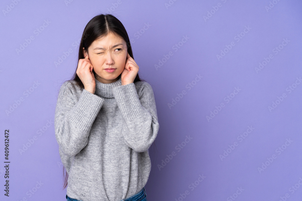 Young asian woman over isolated background frustrated and covering ears Young asian woman over isolated background frustrated and covering ears