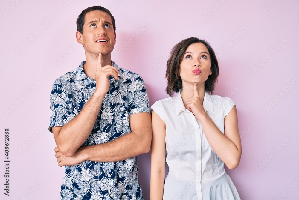 Beautiful couple wearing casual clothes thinking concentrated about doubt with finger on chin and looking up wondering Beautiful couple wearing casual clothes thinking concentrated about doubt with finger on chin and looking up wondering