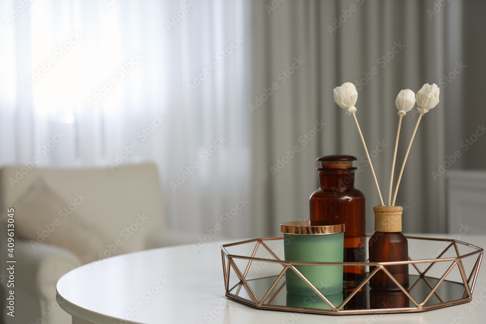 Air reed freshener and candle on white table in room, space for text Air reed freshener and candle on white table in room, space for text