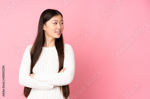 Young asian woman over isolated background with arms crossed and happy © luismolinero