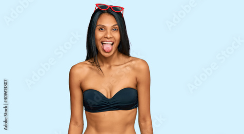 Young african american woman wearing bikini sticking tongue out happy with funny expression. emotion concept. © Krakenimages.com