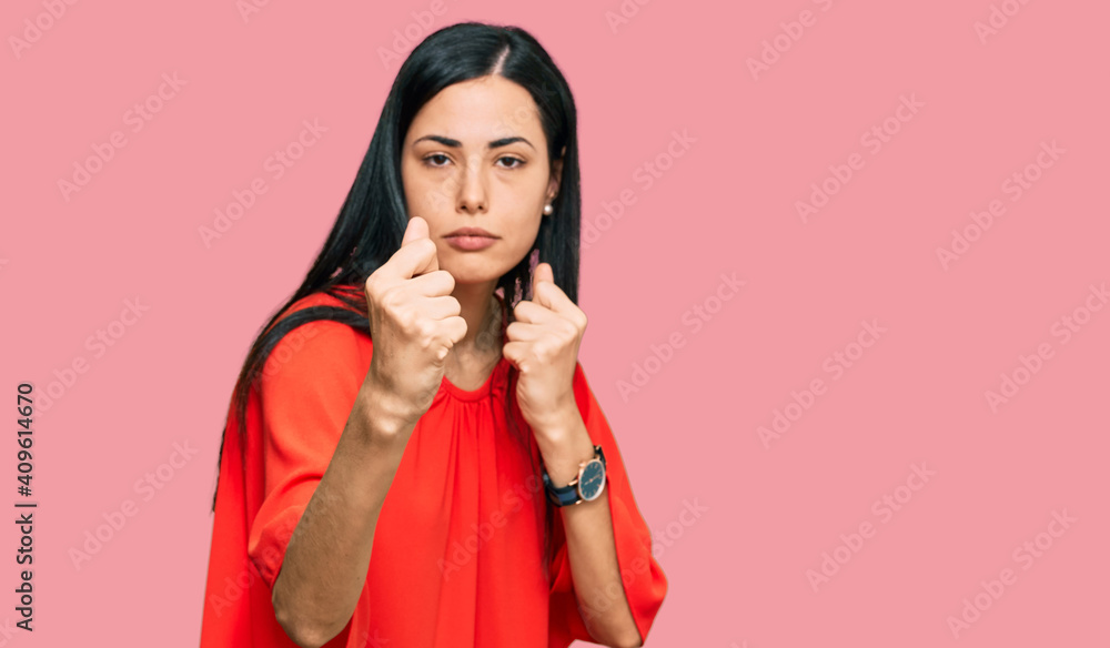 Beautiful young woman wearing casual clothes ready to fight with fist defense gesture, angry and upset face, afraid of problem