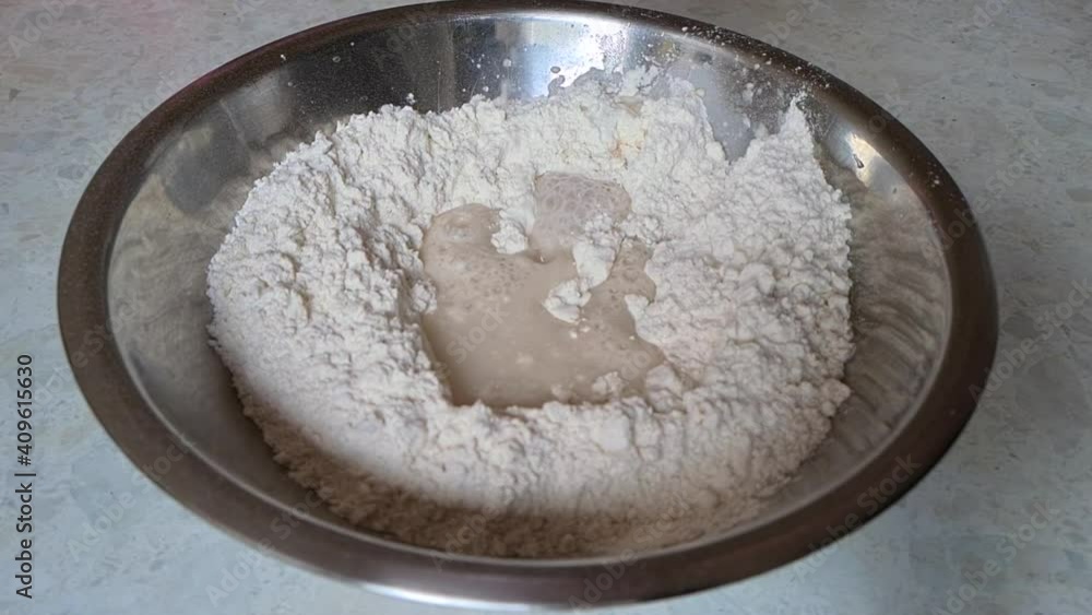 slow motion of adding water to a bowl of flour to make dough slow motion of adding water to a bowl of flour to make dough