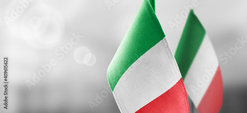 Small national flags of the Italy on a light blurry background