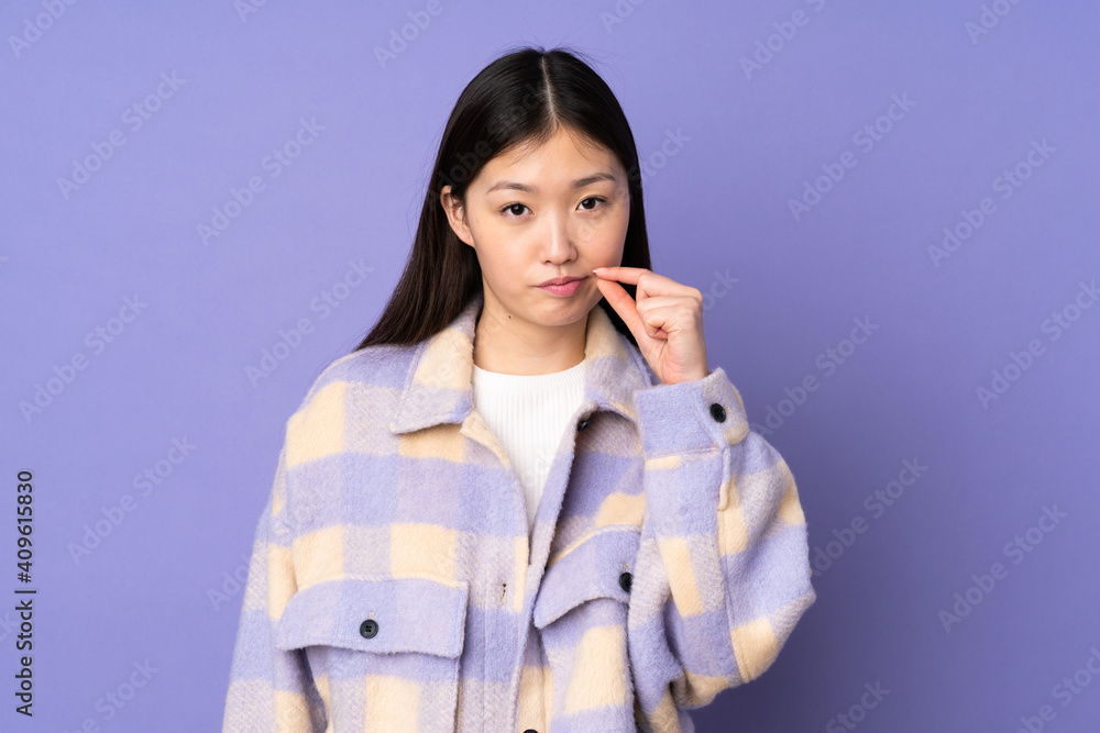 Young asian woman isolated on purple background showing a sign of silence gesture Young asian woman isolated on purple background showing a sign of silence gesture