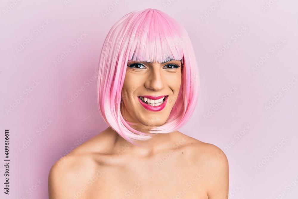 Young man wearing woman make up wearing pink wig with a happy and cool smile on face. lucky person. Young man wearing woman make up wearing pink wig with a happy and cool smile on face. lucky person.